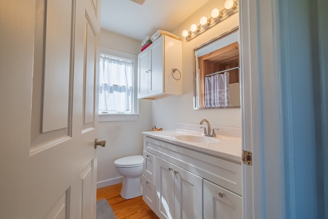 bathroom with hardwood / wood-style floors, vanity, and toilet