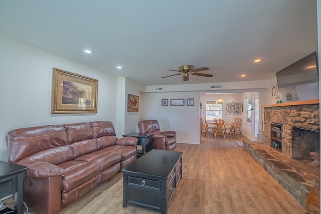 living room with a fireplace, hardwood / wood-style flooring, and ceiling fan