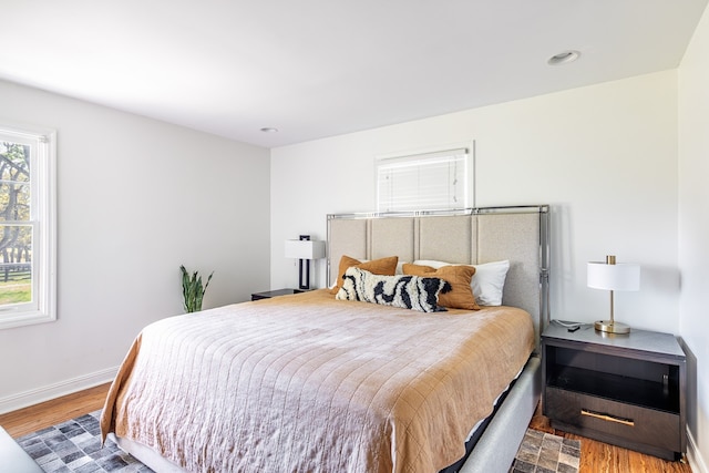 bedroom featuring baseboards, wood finished floors, and recessed lighting