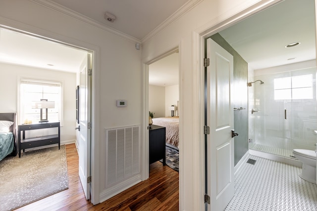 ensuite bathroom featuring a stall shower, visible vents, crown molding, and ensuite bath