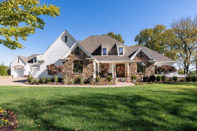 craftsman house featuring stone siding, a front yard, a garage, and driveway