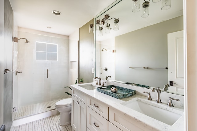 full bathroom featuring toilet, a stall shower, double vanity, and a sink