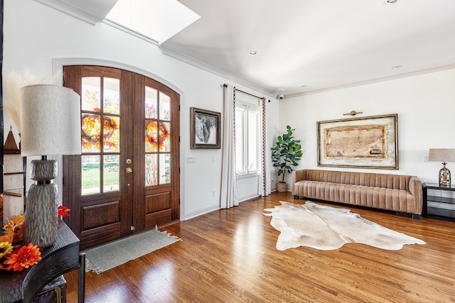 entryway featuring ornamental molding, french doors, a healthy amount of sunlight, and wood finished floors