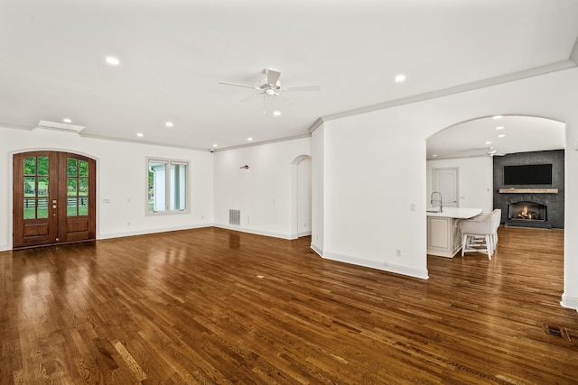1702 Old Hillsboro Rd, Franklin, TN 37069 - unfurnished living room featuring a ceiling fan, a fireplace, dark wood finished floors, arched walkways, and recessed lighting