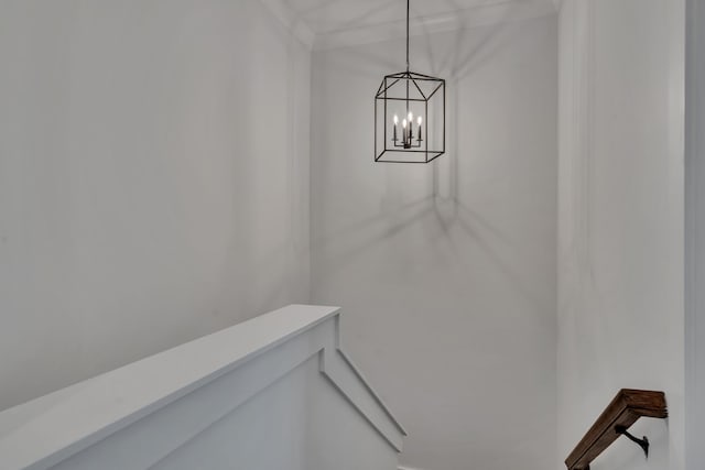 staircase with a notable chandelier