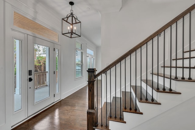 foyer entrance with dark hardwood / wood-style flooring and a chandelier