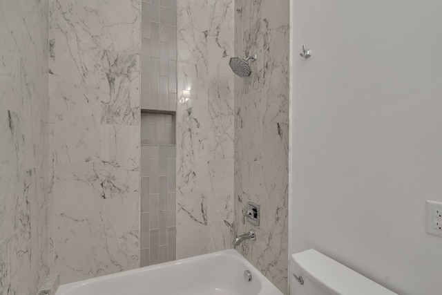 bathroom featuring toilet and tiled shower / bath combo