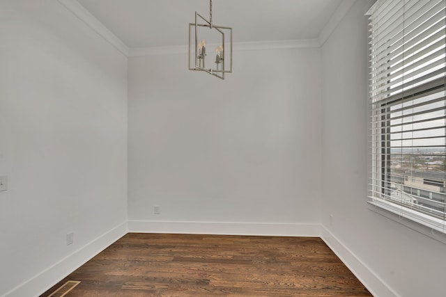 unfurnished dining area featuring a chandelier, dark hardwood / wood-style flooring, and crown molding