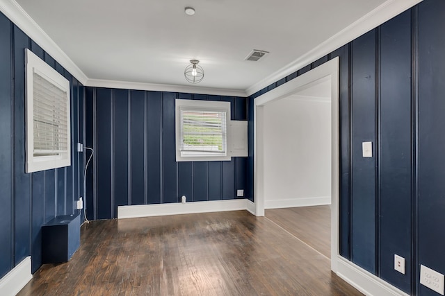 spare room featuring ornamental molding and dark hardwood / wood-style flooring