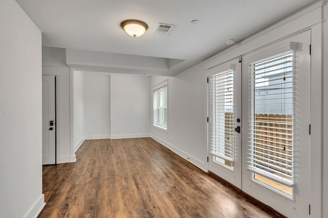 empty room featuring french doors and dark hardwood / wood-style floors