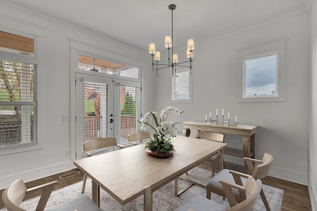 dining room featuring ornamental molding, hardwood / wood-style flooring, plenty of natural light, and a notable chandelier