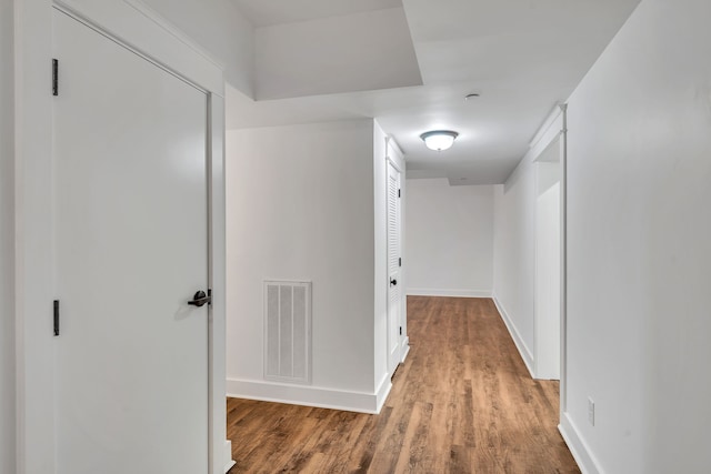 corridor with hardwood / wood-style flooring