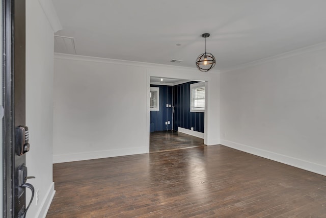 empty room featuring ornamental molding and dark wood-type flooring