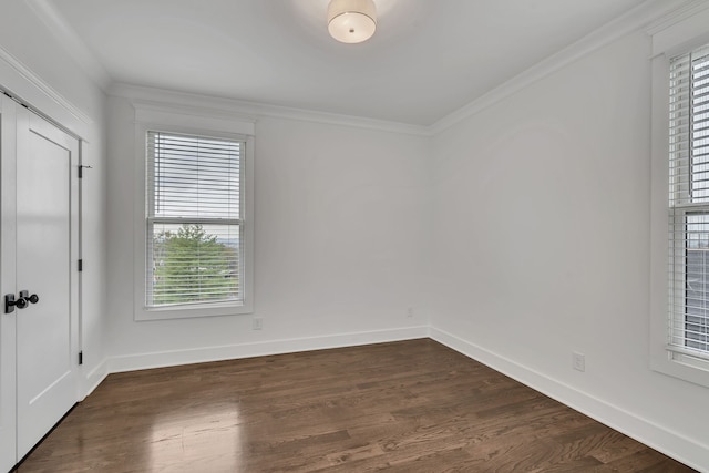 unfurnished room featuring ornamental molding and dark wood-type flooring