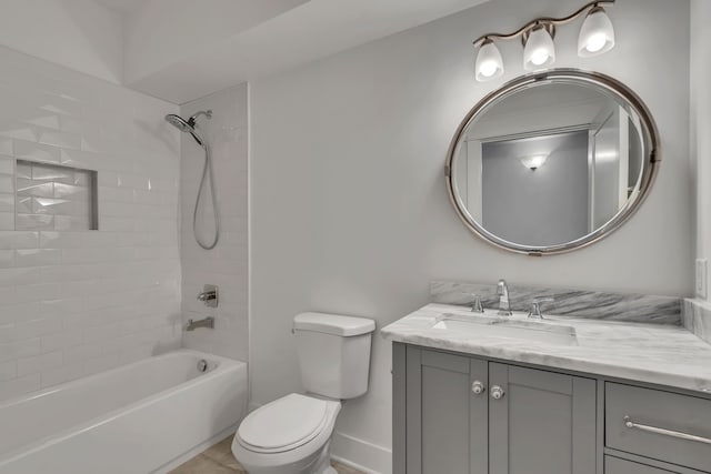 full bathroom with vanity, tiled shower / bath combo, and toilet