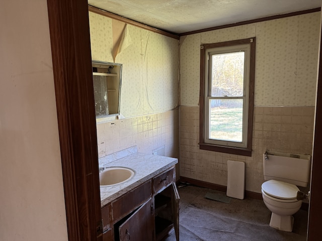 bathroom featuring ornamental molding, a textured ceiling, vanity, tile walls, and toilet