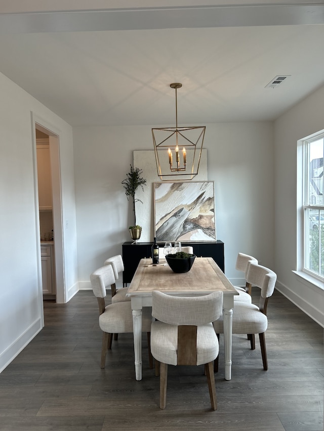 dining area with dark hardwood / wood-style floors and a notable chandelier