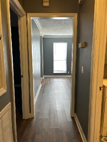 hallway featuring a textured ceiling and dark hardwood / wood-style floors