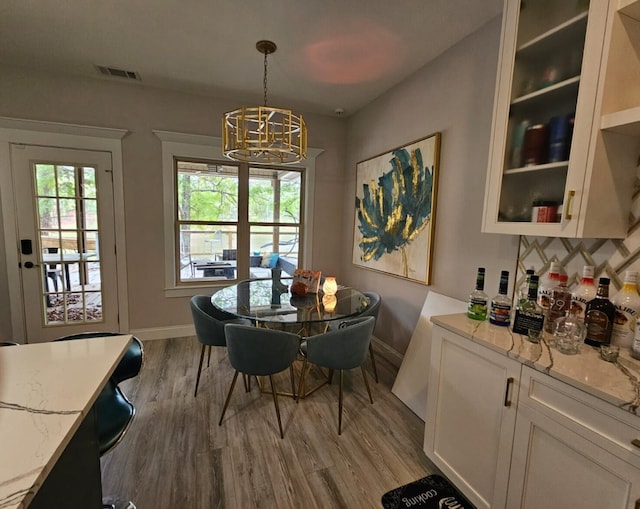 dining room with hardwood / wood-style flooring and an inviting chandelier