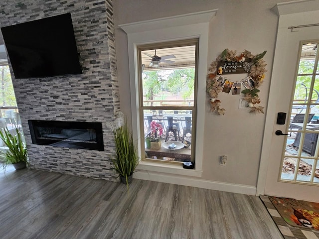 living room featuring a fireplace, hardwood / wood-style floors, and ceiling fan