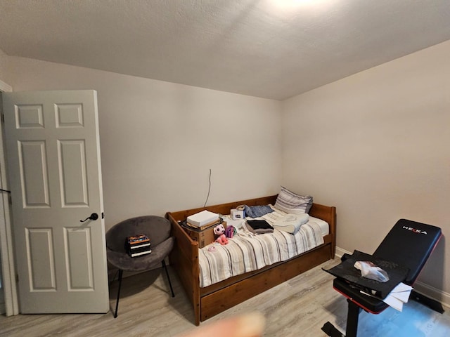 bedroom featuring wood-type flooring and a textured ceiling