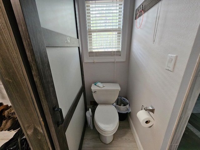 bathroom with hardwood / wood-style flooring and toilet