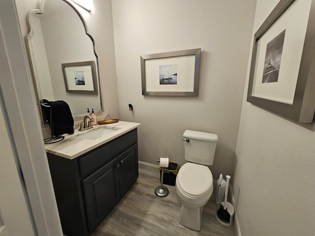 bathroom featuring toilet, vanity, and hardwood / wood-style flooring