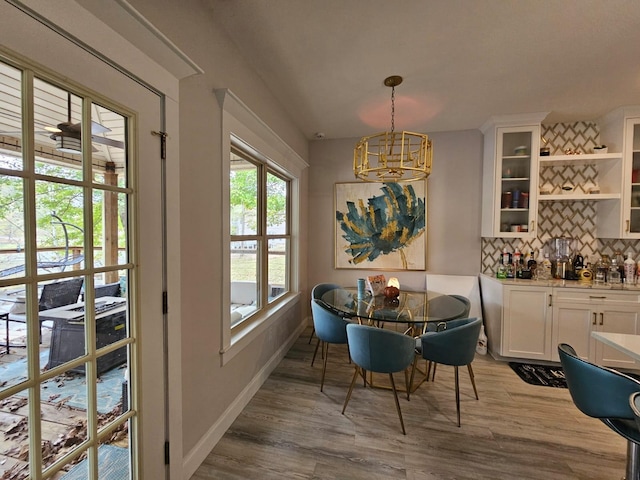 dining space with light hardwood / wood-style floors and an inviting chandelier