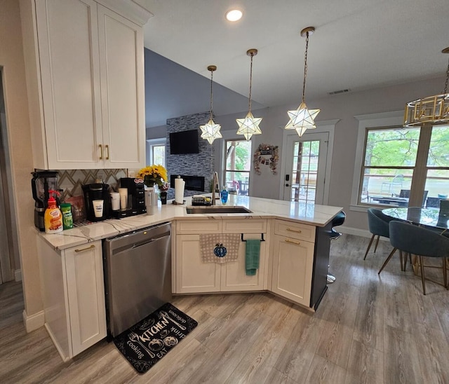 kitchen with a healthy amount of sunlight, sink, white cabinets, and stainless steel dishwasher