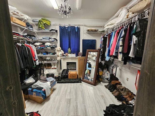 walk in closet featuring hardwood / wood-style flooring and an inviting chandelier