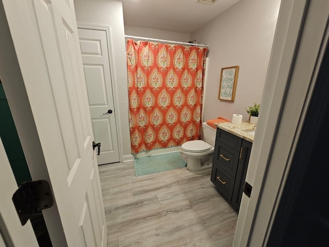 bathroom featuring a shower with curtain, vanity, wood-type flooring, and toilet