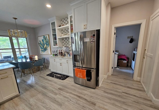 kitchen with stainless steel fridge with ice dispenser, light wood-type flooring, decorative light fixtures, and white cabinetry