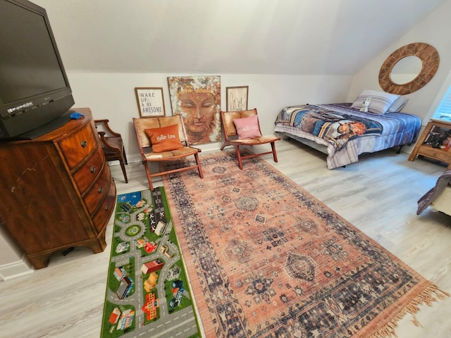 bedroom with light hardwood / wood-style flooring and lofted ceiling