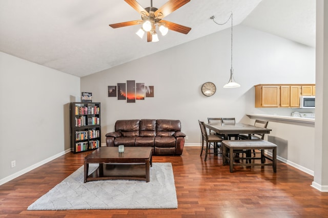 living room featuring dark hardwood / wood-style floors, high vaulted ceiling, and ceiling fan