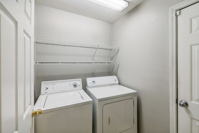 washroom with a textured ceiling and independent washer and dryer