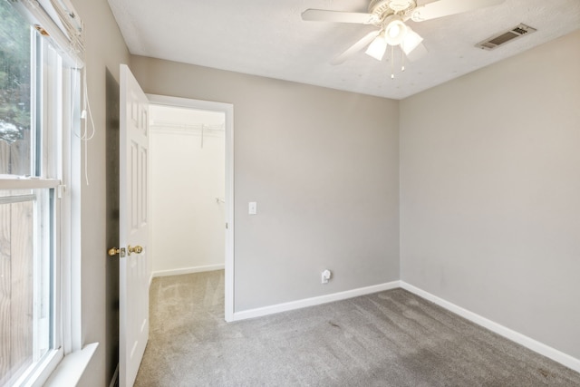 spare room with ceiling fan and light colored carpet