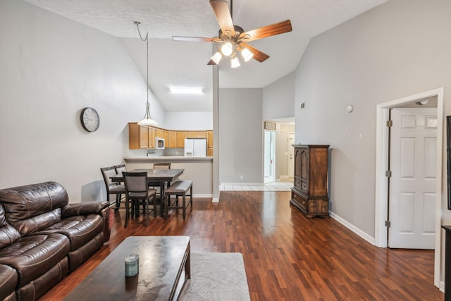 living room with ceiling fan, dark hardwood / wood-style flooring, high vaulted ceiling, and a textured ceiling