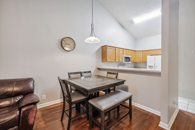 dining area featuring high vaulted ceiling and dark hardwood / wood-style floors