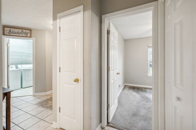 hall with washer and dryer and light carpet