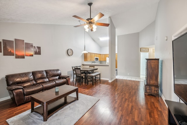 living room with a textured ceiling, dark hardwood / wood-style floors, high vaulted ceiling, and ceiling fan