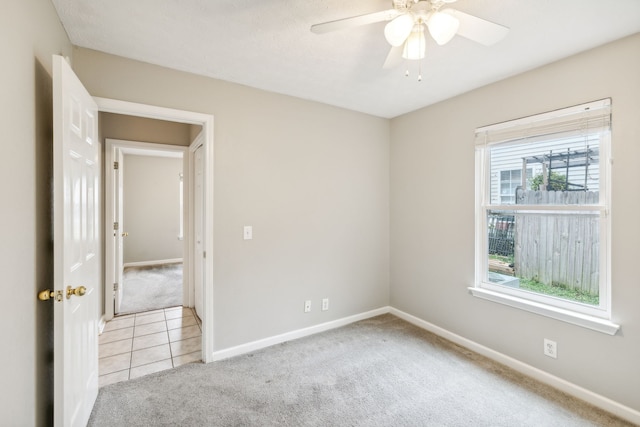 carpeted empty room featuring ceiling fan