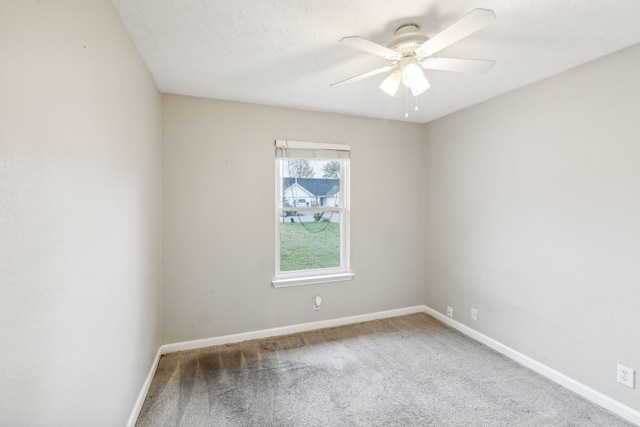 carpeted spare room featuring ceiling fan and a textured ceiling