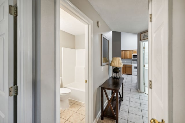 hallway featuring light tile patterned floors and a textured ceiling