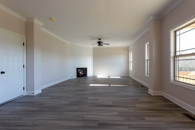 unfurnished living room featuring dark hardwood / wood-style flooring, a large fireplace, ceiling fan, and crown molding