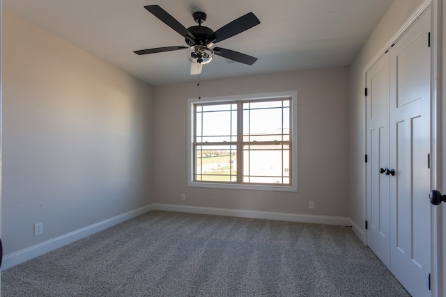 carpeted spare room featuring ceiling fan