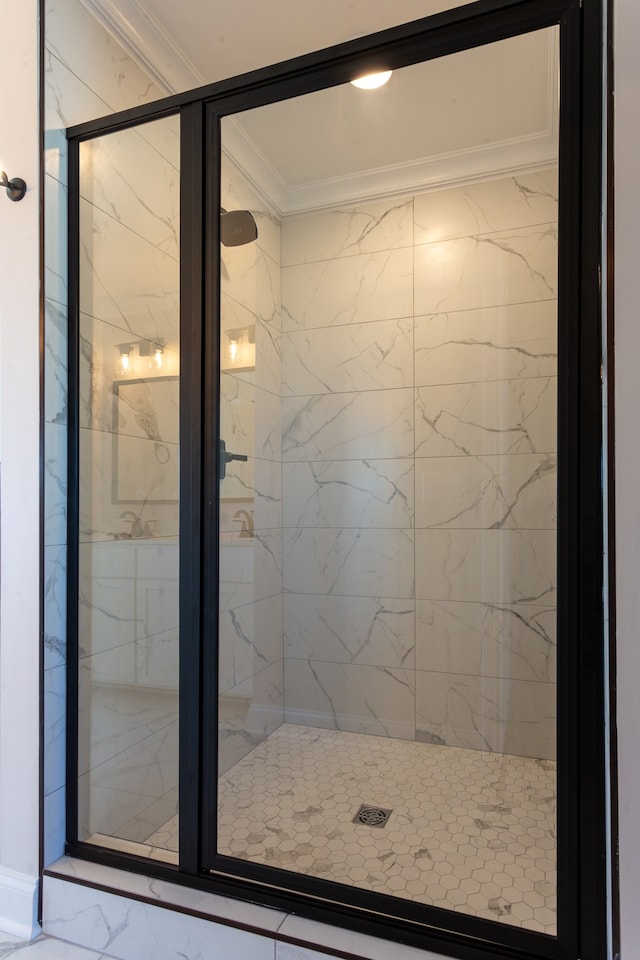 bathroom with a shower with shower door and crown molding