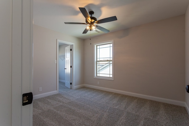 carpeted spare room featuring ceiling fan