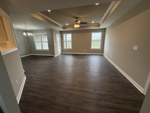 unfurnished living room with ceiling fan with notable chandelier, dark hardwood / wood-style floors, a raised ceiling, and crown molding