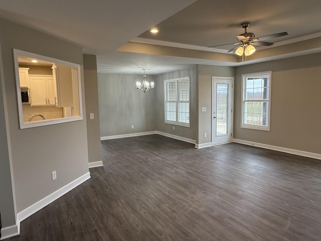 unfurnished living room featuring ceiling fan with notable chandelier and dark wood-type flooring