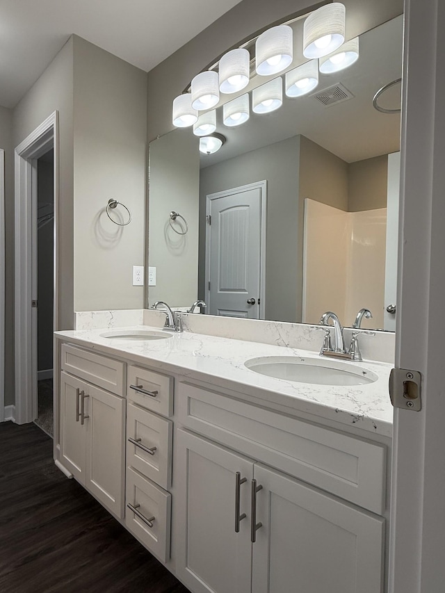 bathroom featuring hardwood / wood-style floors, vanity, and walk in shower